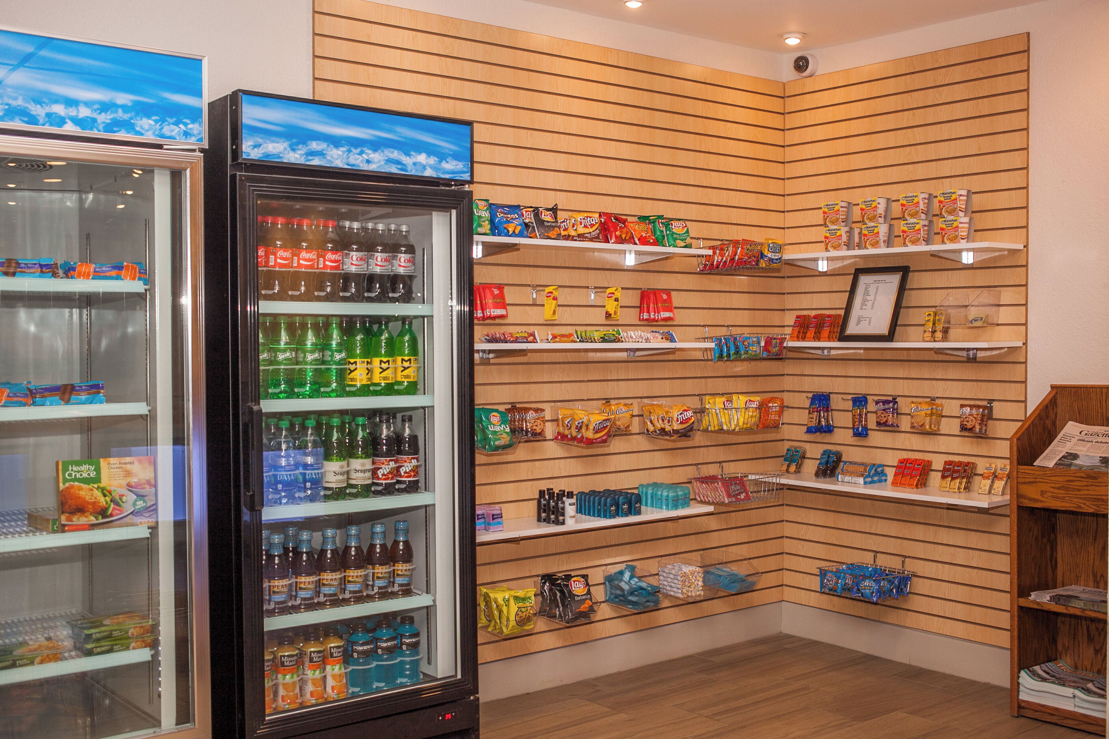 A store interior with shelves stocked with snacks, beverages, and packaged goods.