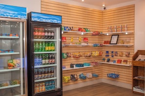 A store interior with shelves stocked with snacks, beverages, and packaged goods.
