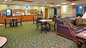 A hotel lobby with a coffee station, seating area, and a large window. - Holiday Inn Express Hotel & Suites by IHG (Logan)