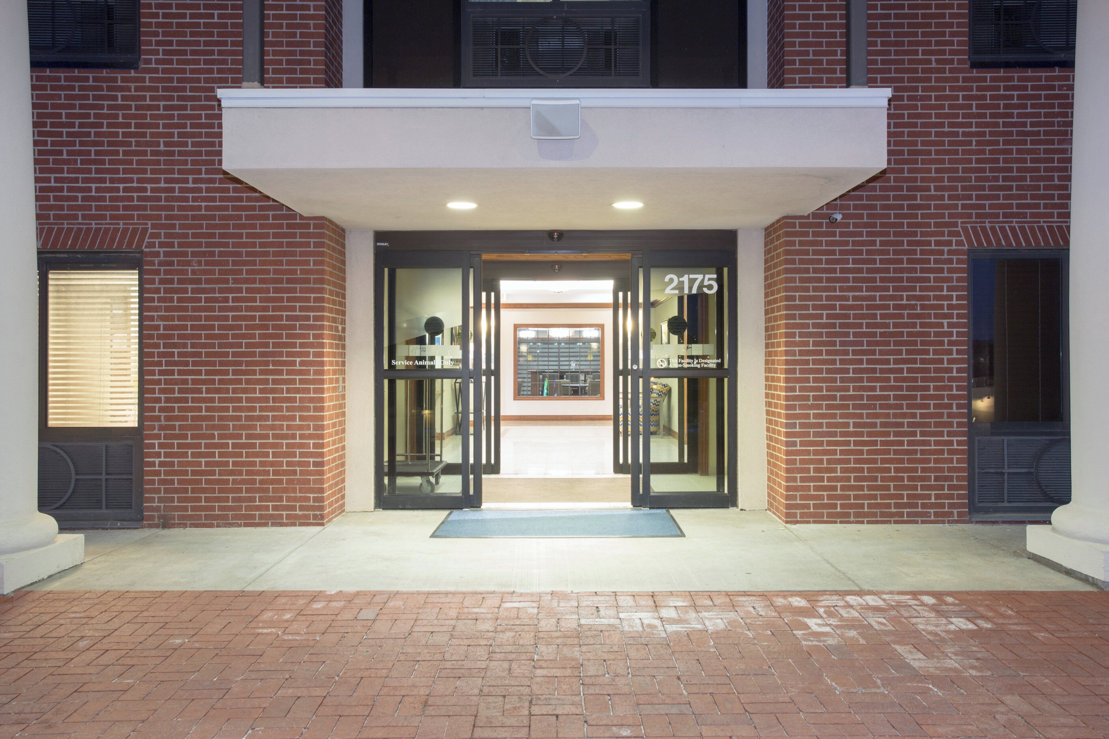 A building entrance with a brick facade, a numbered door, and a small awning above the entrance.