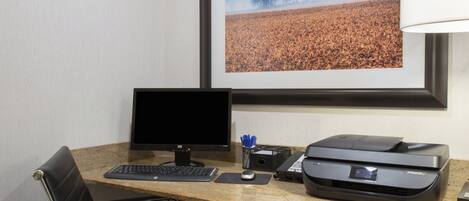 Un escritorio con monitor de computadora, teclado, ratón e impresora.