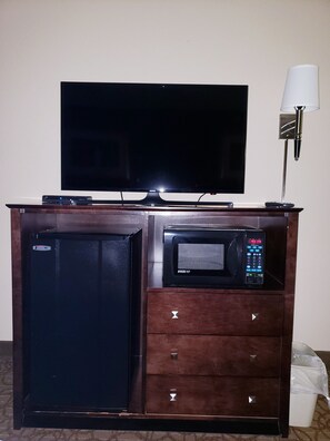 A compact kitchenette with a microwave, refrigerator, and a flat-screen TV. - Holiday Inn Express Hotel & Suites Concordia by IHG (Concordia)