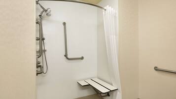 A handicap-accessible shower with grab bars and a shower seat.
