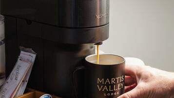 Una máquina de café sirviendo café en una taza con la etiqueta 'MARTIS VALLEY LODGE'.