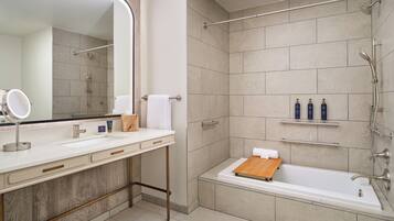 Un bagno moderno con uno specchio grande, un lavandino, una doccia e una vasca da bagno.