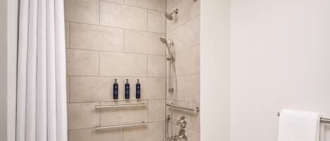 Un baño con bañera, ducha y perchero.