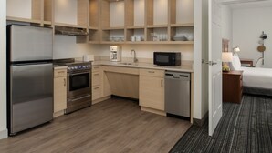 Une cuisine moderne dotée d’appareils électroménagers intégrés, de meubles de rangement en bois et d’un coin repas séparé.