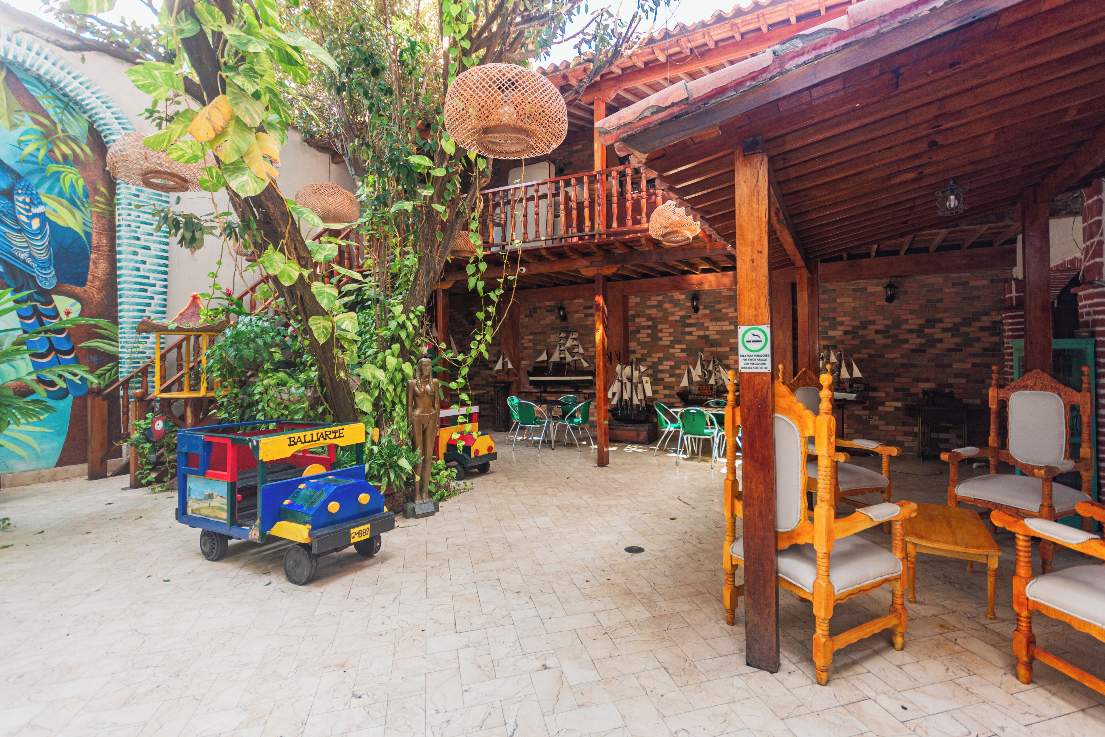 Un espacio al aire libre rústico con mobiliario de madera y un pequeño vehículo de juegos.