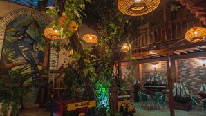 An outdoor area with a tree, a small vehicle, and hanging lights.