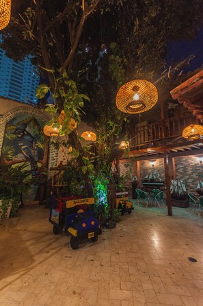 An outdoor area with a tree, a small vehicle, and hanging lights. - Baluarte Cartagena Hotel Boutique (Cartagena)
