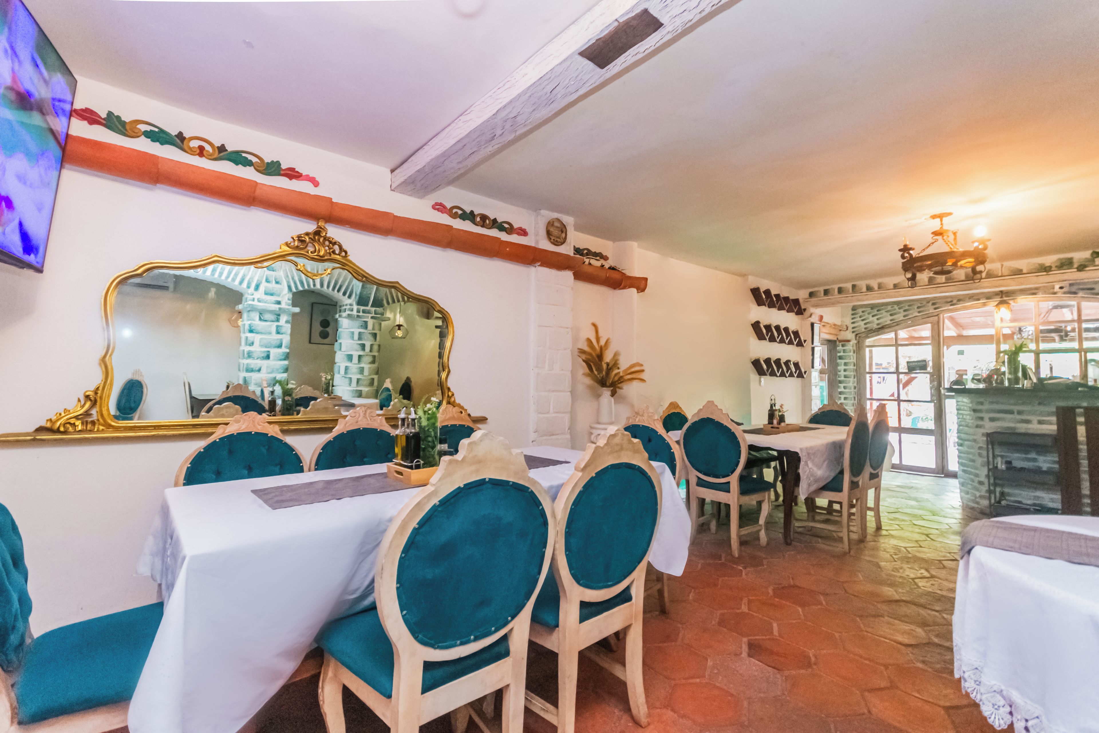 Un ristorante con sedie e tavoli di legno, un grande specchio e un camino.