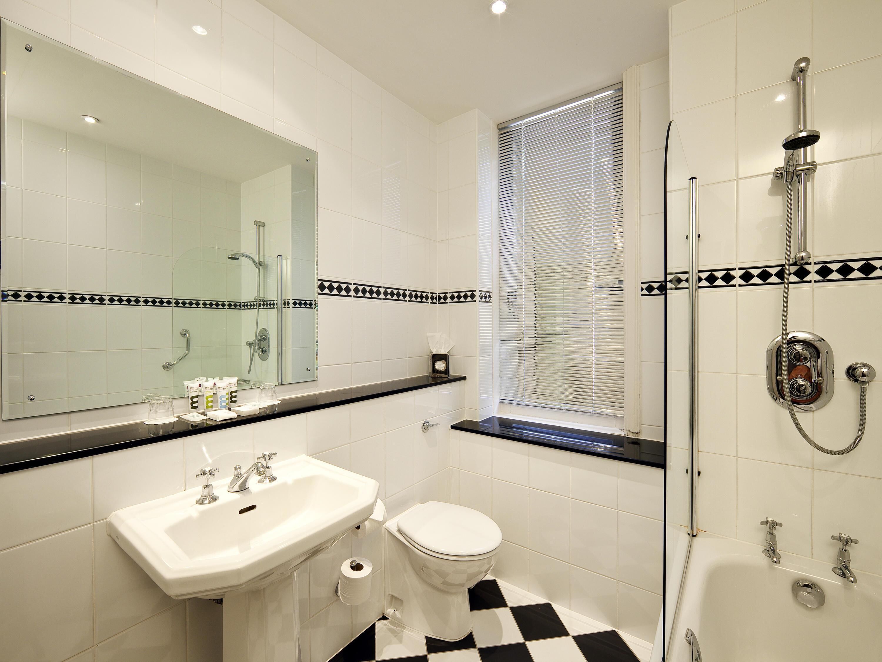 A bathroom with a sink, toilet, and shower.