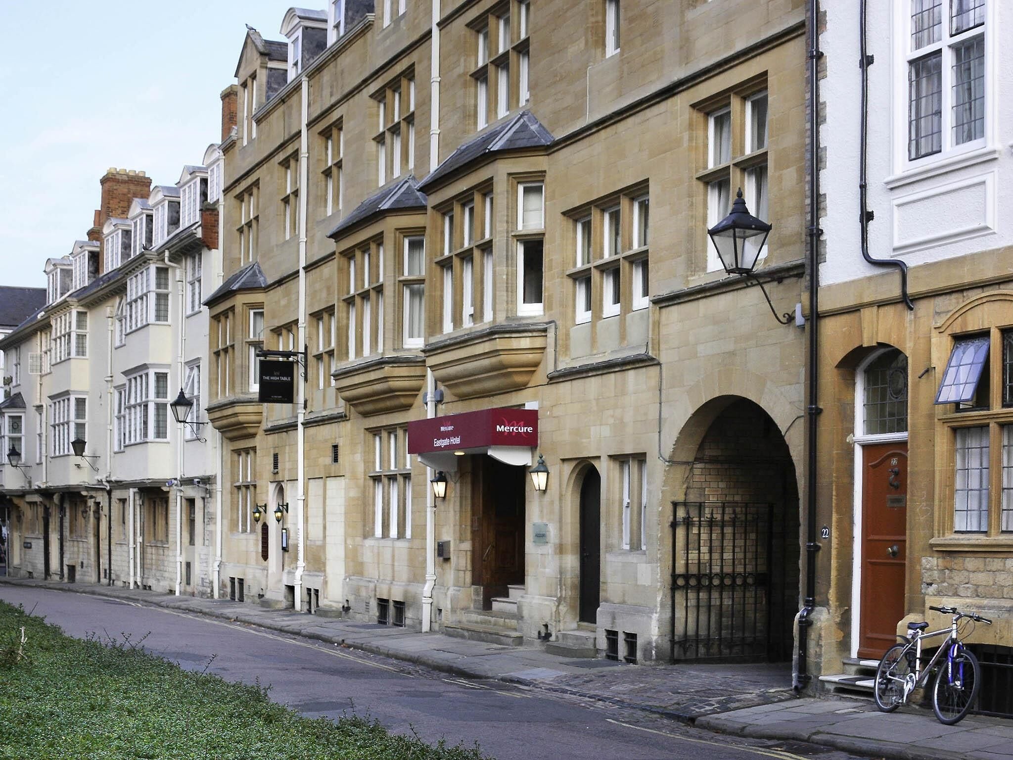 A row of traditional stone buildings with a prominent red awning indicating a Mercure hotel.