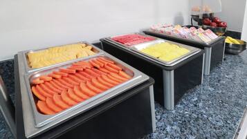 Un bufé con diversos alimentos presentados en bandejas.