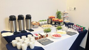Ein reichhaltiges Buffet mit Speisen, Getränken und Thermoskannen.
