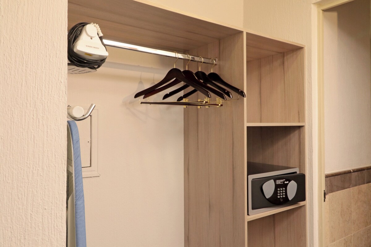 A closet with wooden shelving, a hanging rack, and a radio.