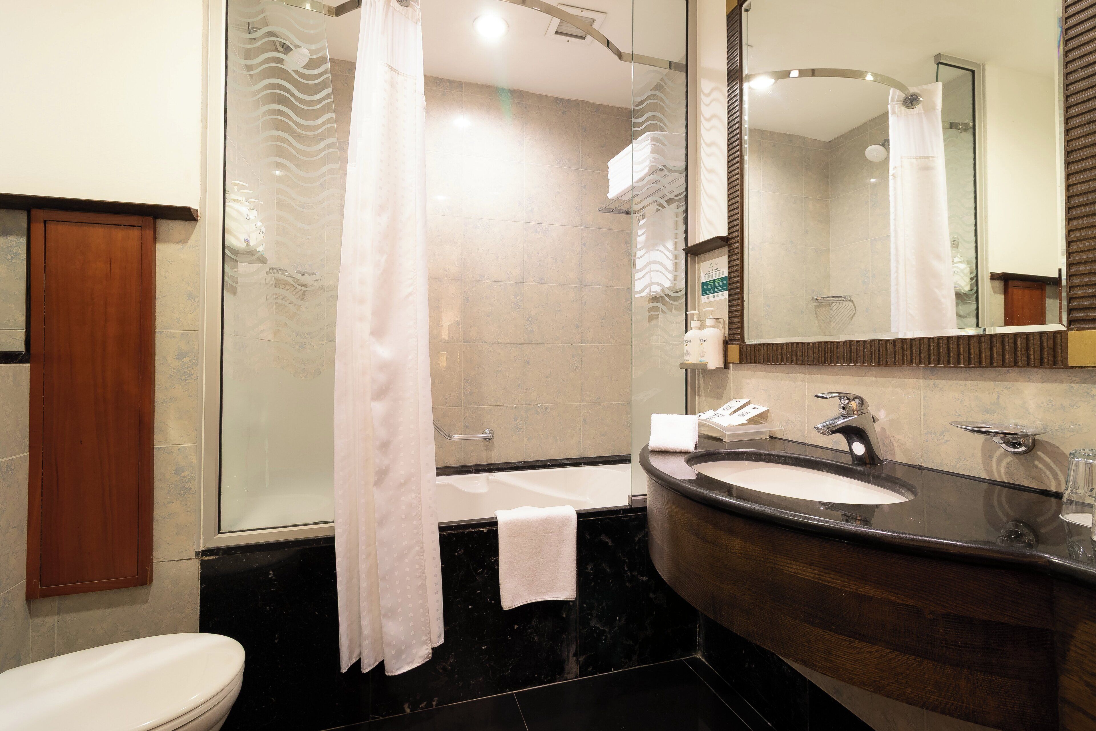 ميني بار وخزنة داخل الغرفة ومكتب وستائر تعتيم