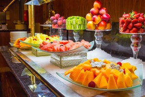 A buffet with various fruits and desserts.