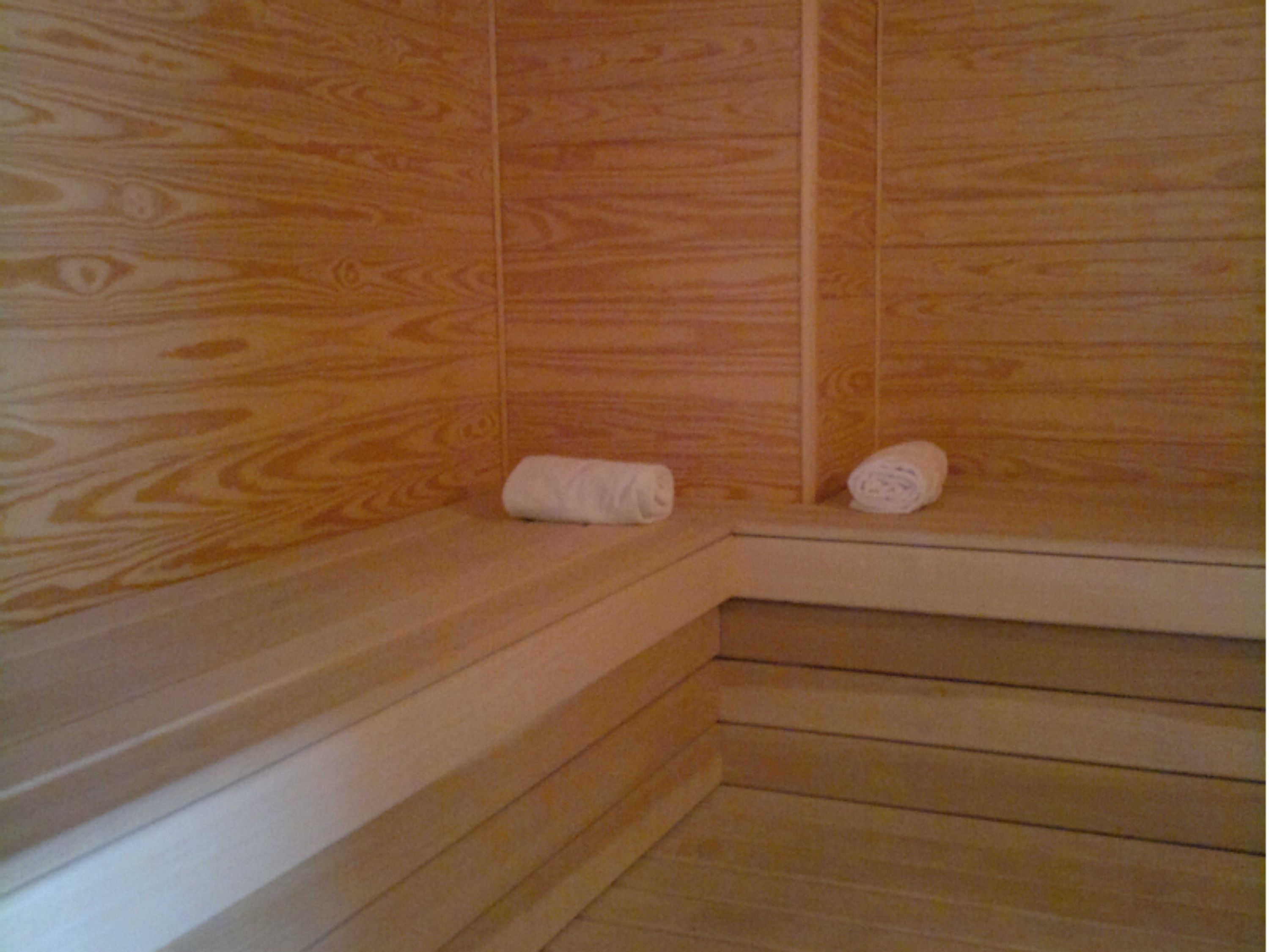 A wooden sauna with benches and towels.