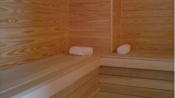 A wooden sauna with benches and towels.