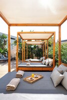 Una piscina al aire libre, sillones reclinables de piscina