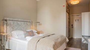 A neatly made bed with a zebra-patterned headboard, bedside lamps, and a bedside table.