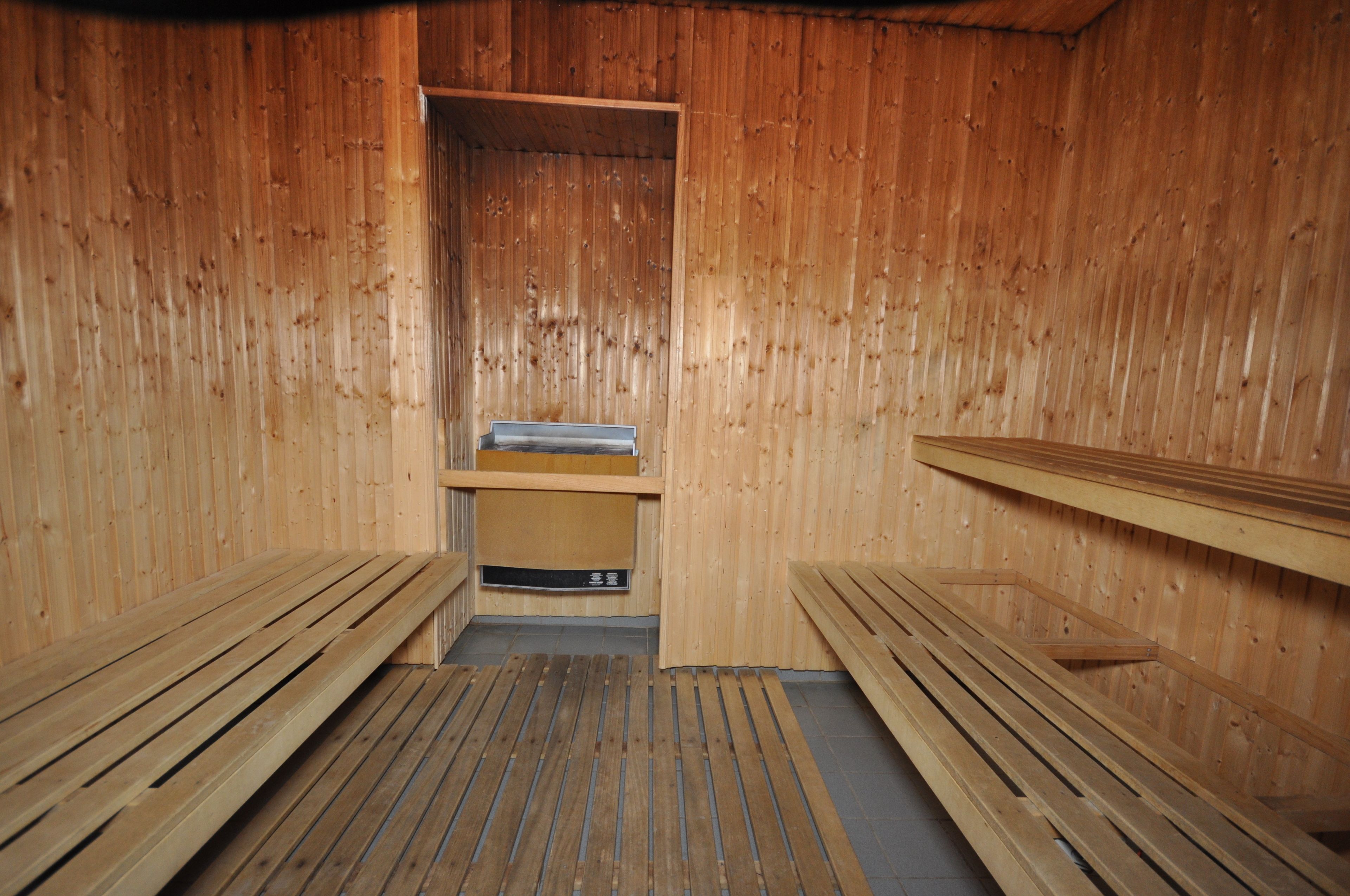 Een sauna met houten banken en een bank in het midden.