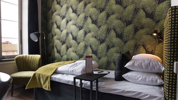 Un dormitorio con una cama, una mesita de noche, una silla, una lámpara y una ventana.