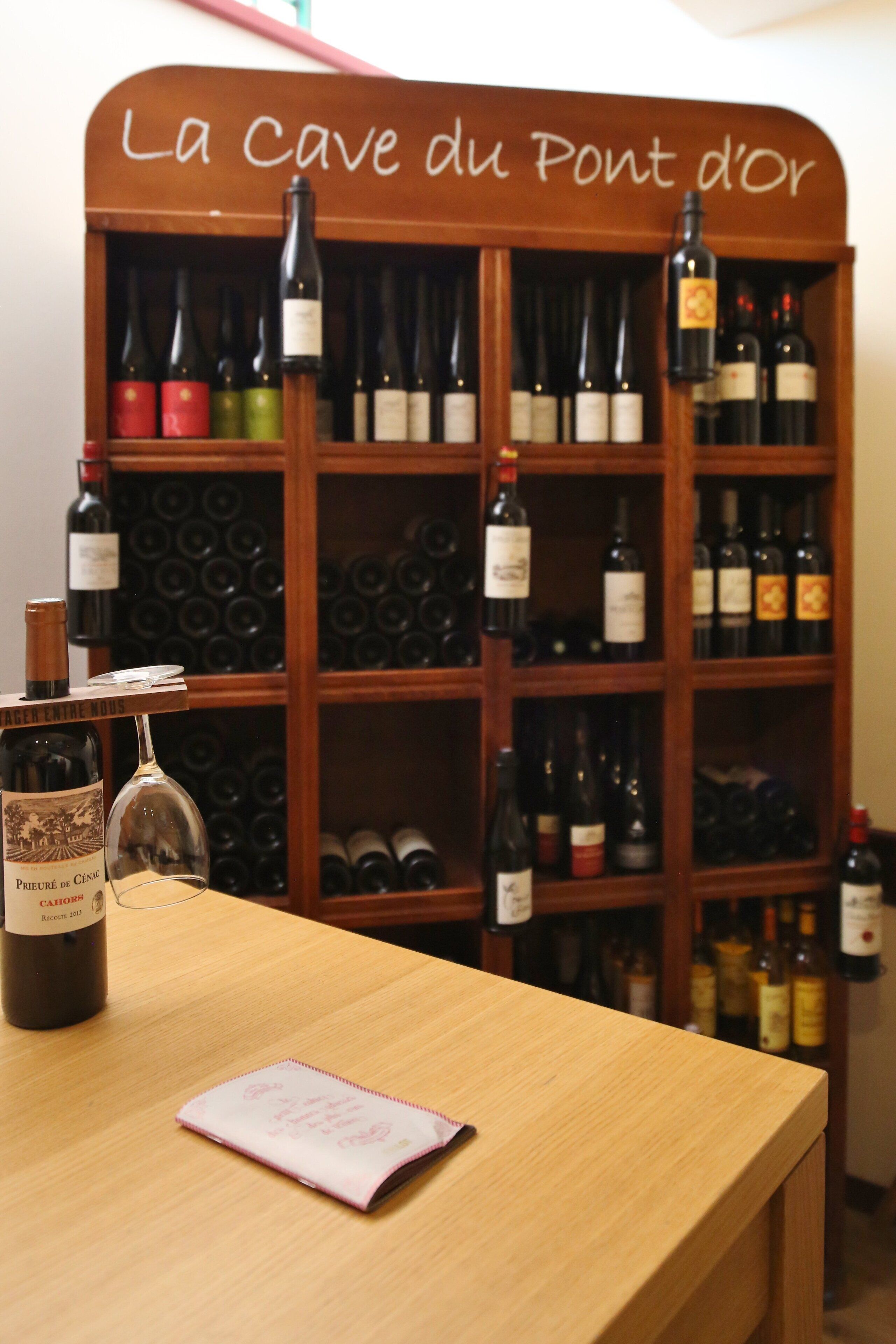 Una bodega con un letrero de madera que dice "La Cave du Pont d'Or".