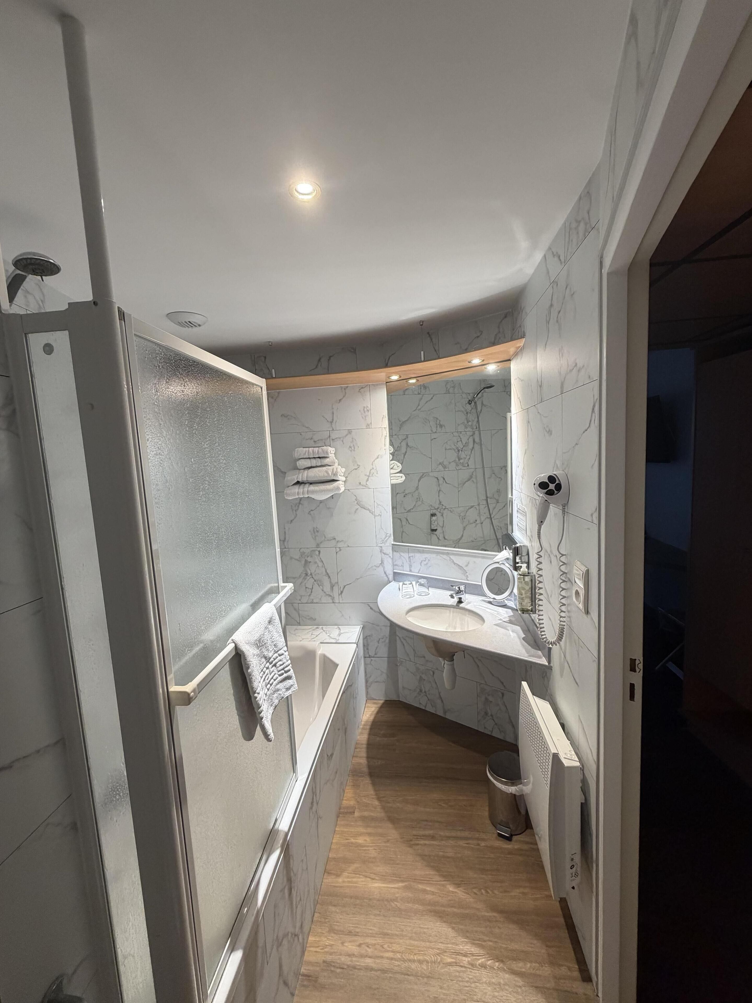A modern bathroom with a built-in shower, a vanity with a sink, and a mirror.