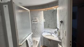 A modern bathroom with a built-in shower, a vanity with a sink, and a mirror.