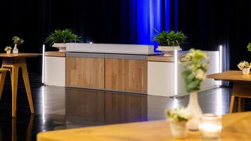 A modern kitchen with a wooden countertop and cabinets, a sink, and two potted plants.