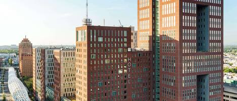 A modern hotel with a distinctive architectural design, featuring a central atrium and multiple floors.