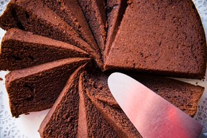 A chocolate cake with multiple slices on a white plate. - Brit Hotel Saint Malo - Le Transat (Saint-Malo)