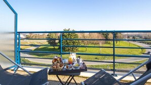 Un balcón con una mesa lista para el desayuno, con vistas a un paisaje pintoresco.