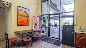 A restaurant with a large window, a vending machine, and a refrigerator. - Travelers Inn (Phoenix)