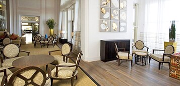 Eine geräumige Lobby mit verschiedenen Sitzbereichen, einem Kamin und Blick auf die Straße.