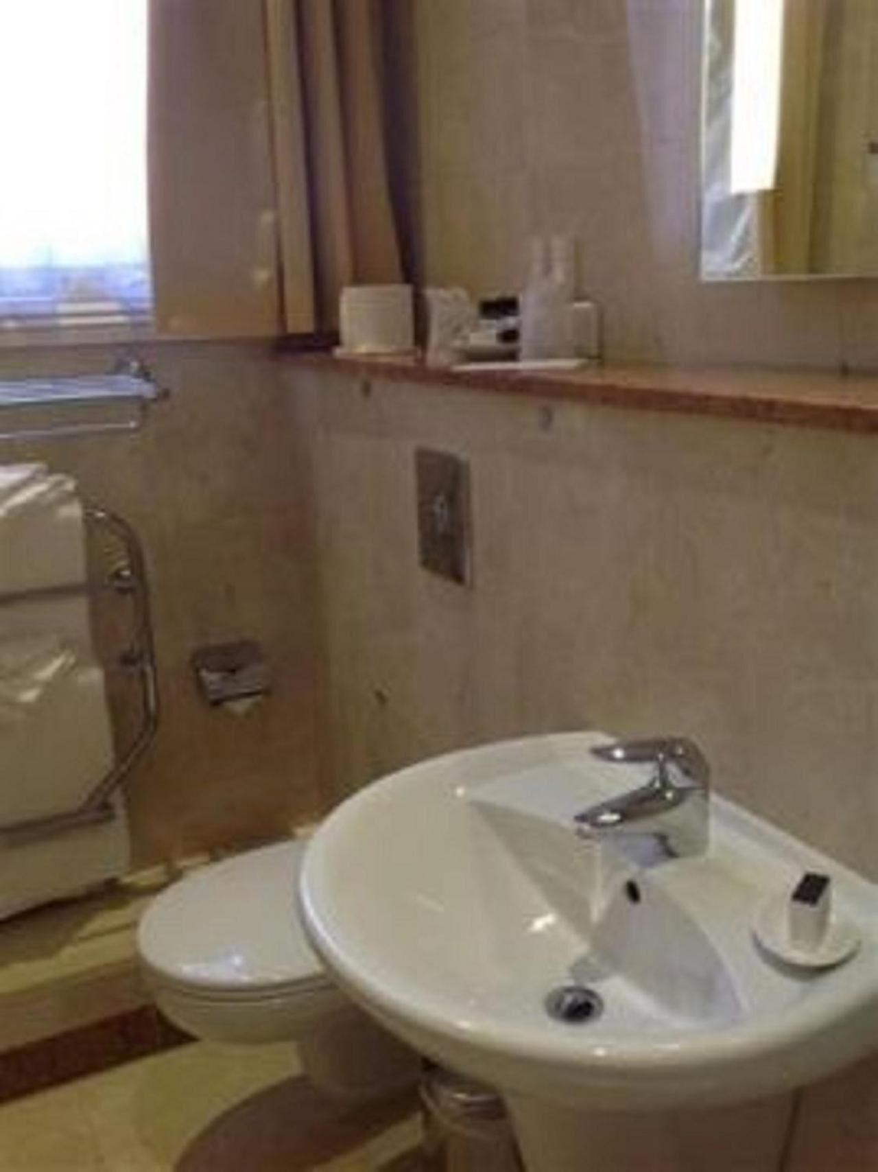 Un baño con inodoro, lavamanos y ducha.