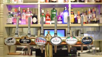 Un bar doté de six robinets à bière, chacun affichant le nom d’une marque, comme Coors Light, Guinness et Stowford Press.