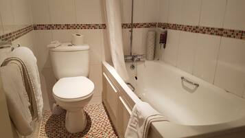 A bathroom with a toilet, bathtub, and shower curtain.