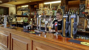 Een bar met verschillende biertaps, een scala aan flessen en een krijtbordmenu.