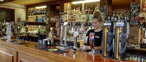 A bar with multiple beer taps, a variety of bottles, and a chalkboard menu.