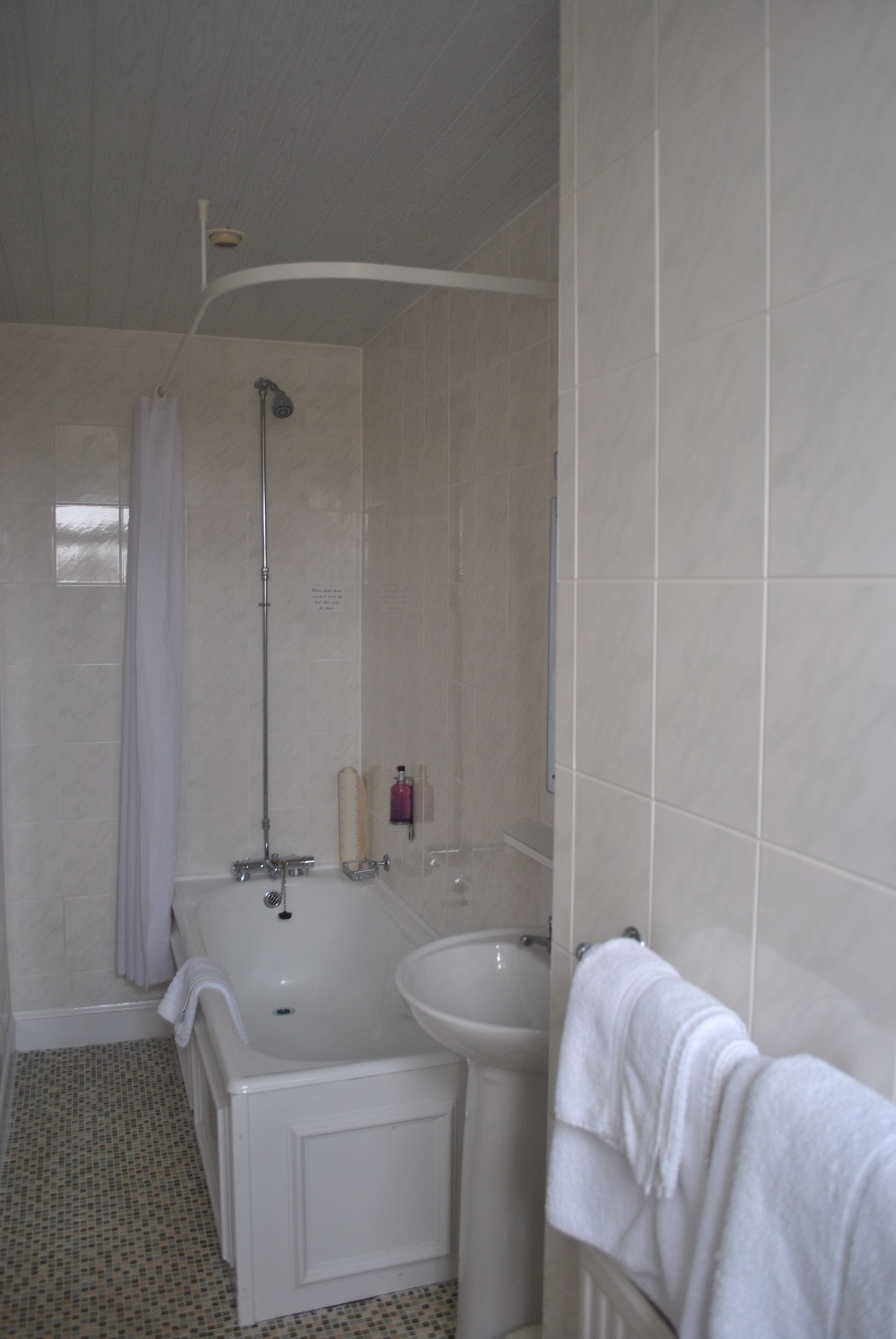 Un bagno con vasca, lavandino e doccia.