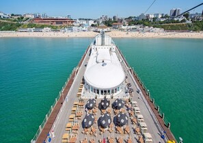 A pier with a circular viewing platform, outdoor seating, and a view of the beach and cityscape. - Brooklands Hotel (Bournemouth)