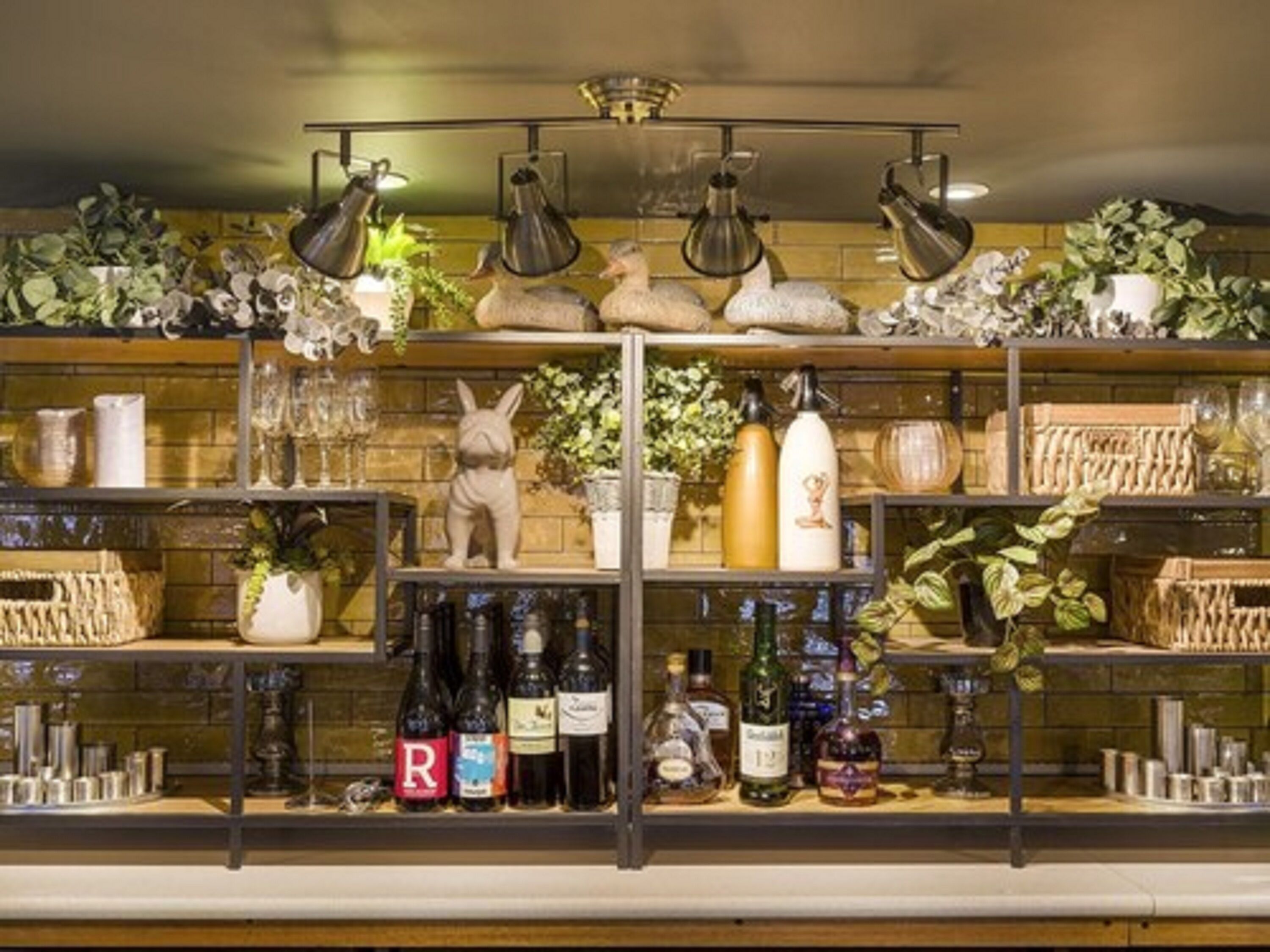 Angolo bar con scaffali che espongono diverse bottiglie e oggetti decorativi.