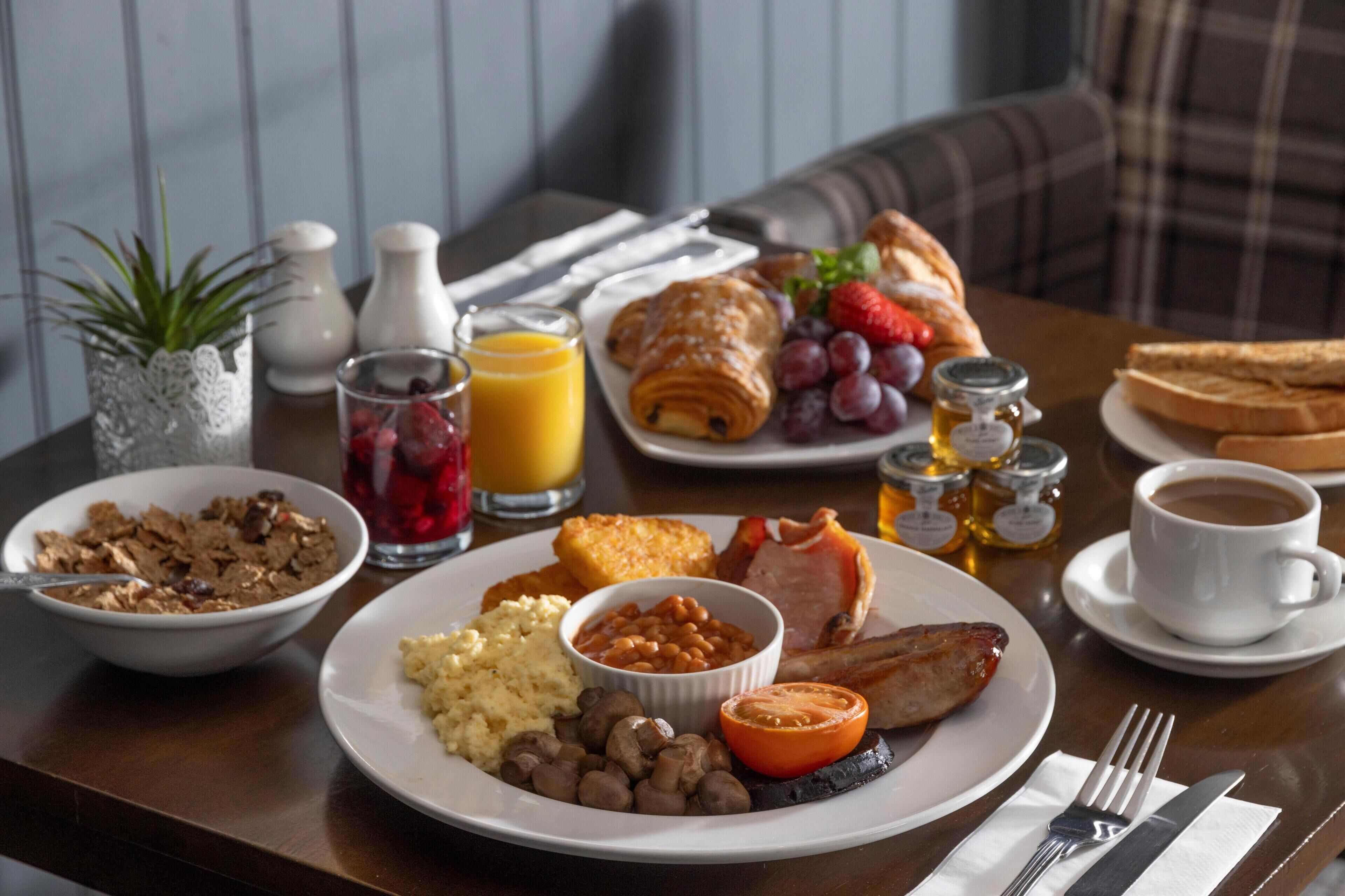 A breakfast table with plates of food, a coffee cup, and a napkin.