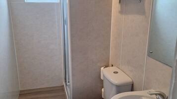 Un baño con inodoro, lavamanos y toallero.