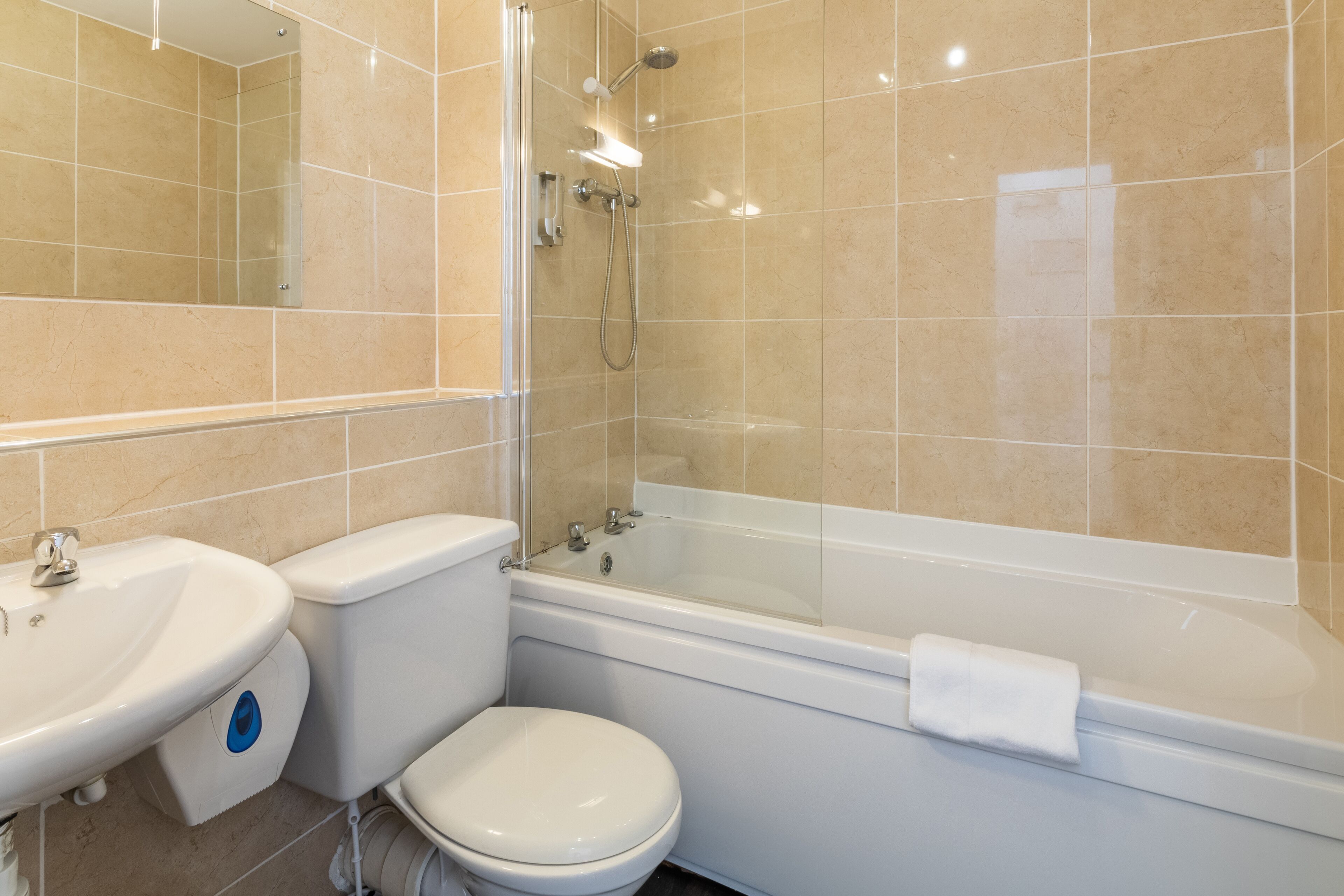A bathroom with a toilet, sink, and bathtub.