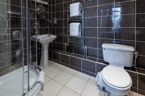 A modern bathroom with a glass-enclosed shower, a pedestal sink, and a toilet.
