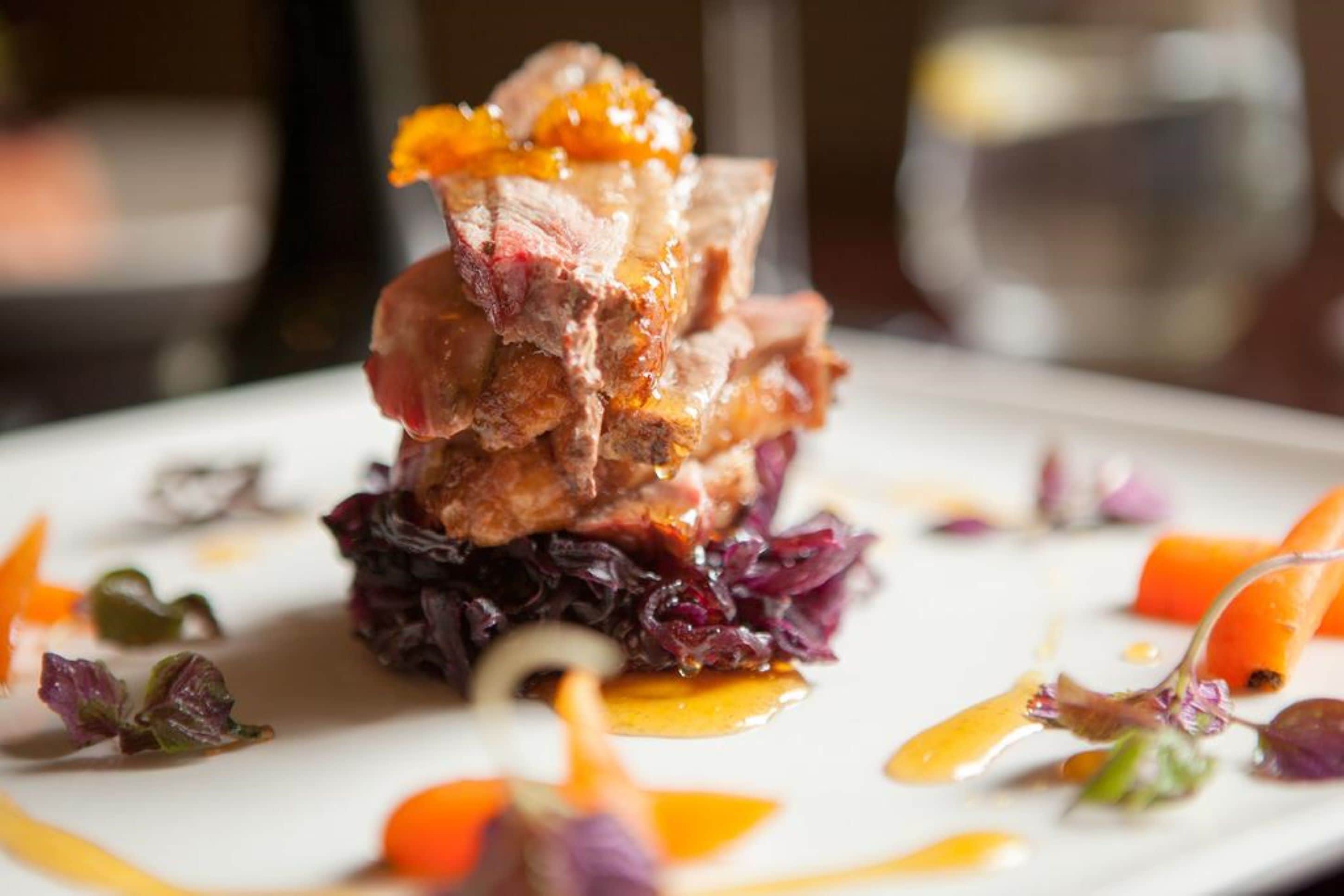 A plated dish with meat, vegetables, and sauce.